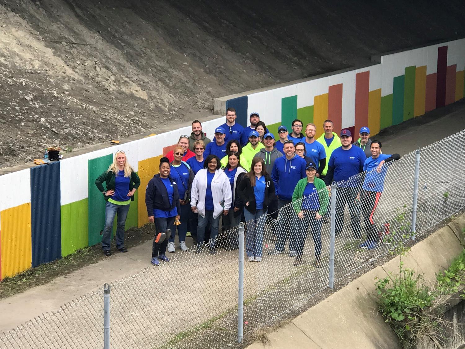 A group of Dominion Energy volunteers standing near a recently painted underpass.