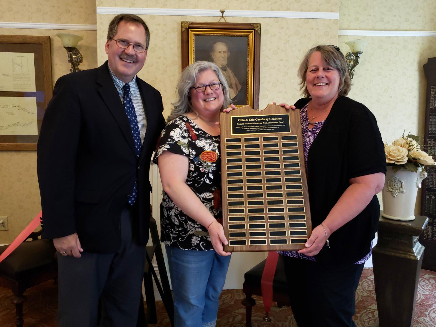 Dan, Karen, and Joyce Bland posing with plaque.