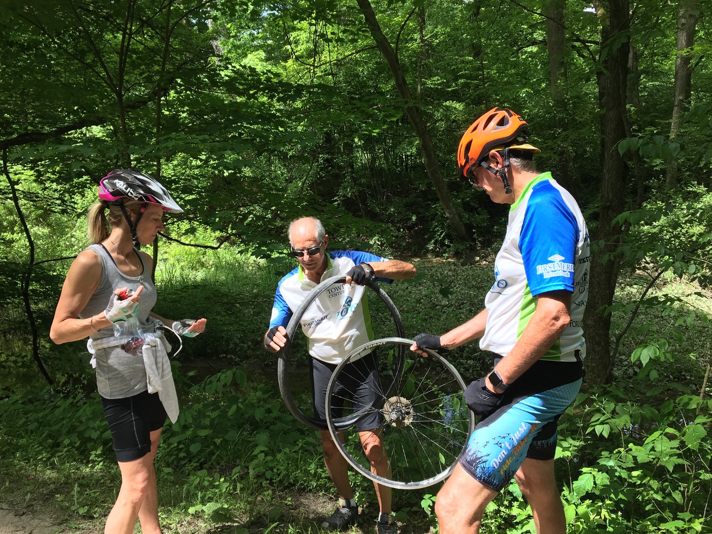 Three century riders repairing a bicycle tire